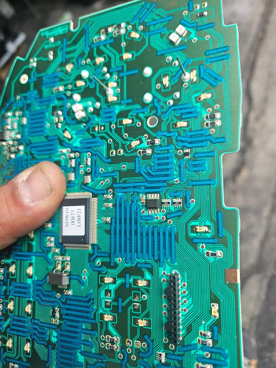 Carte électronique automobile tenue en main, composants visibles