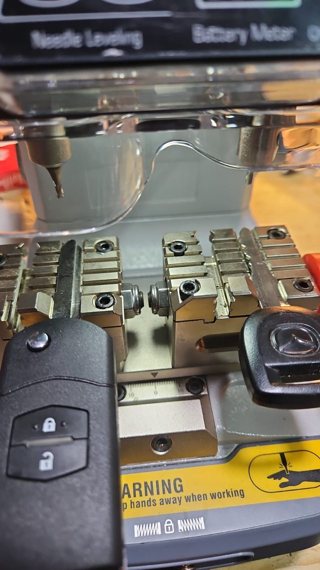 Clé automobile posée devant une mallette d’outillage électronique