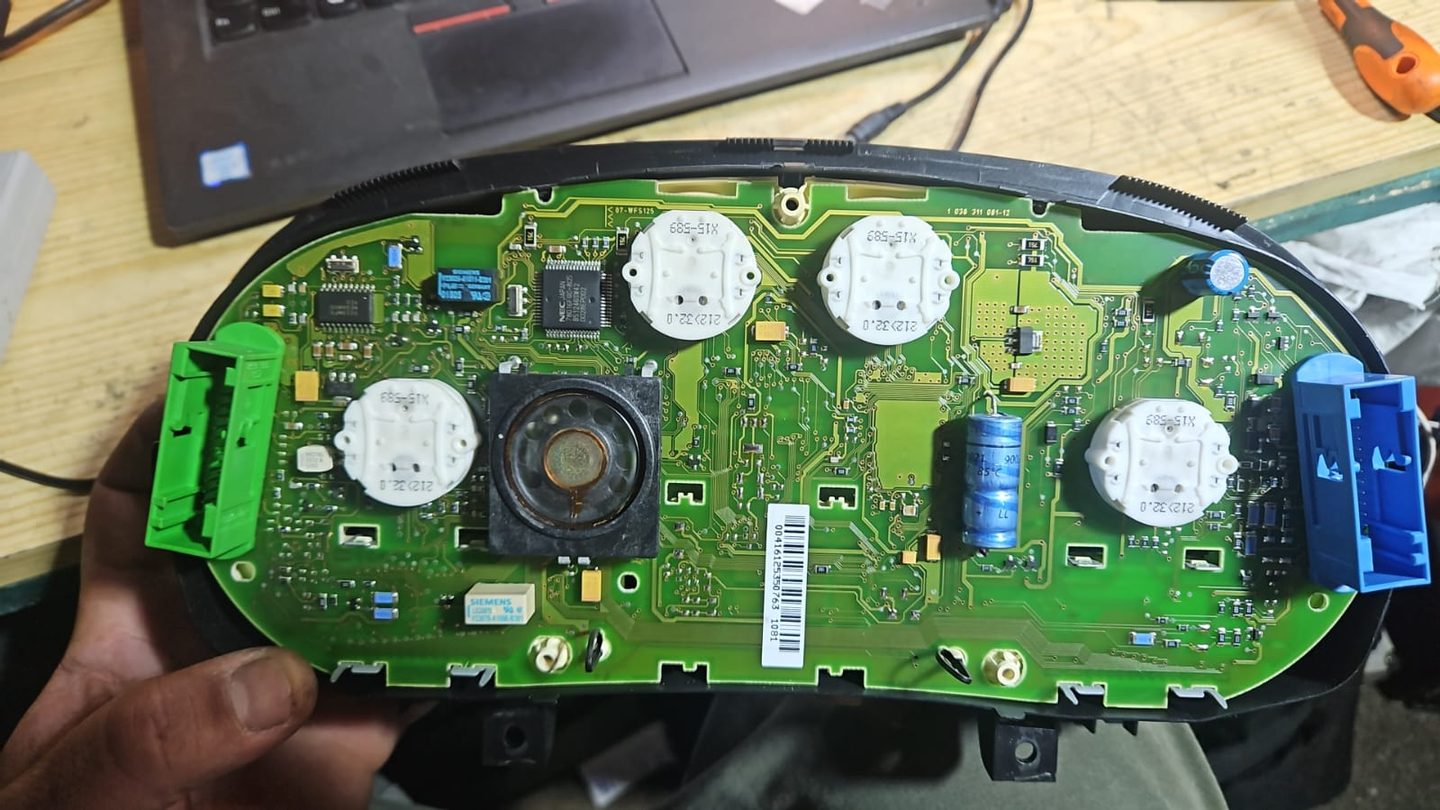 Combiné d’instruments et carte électronique posés sur un établi